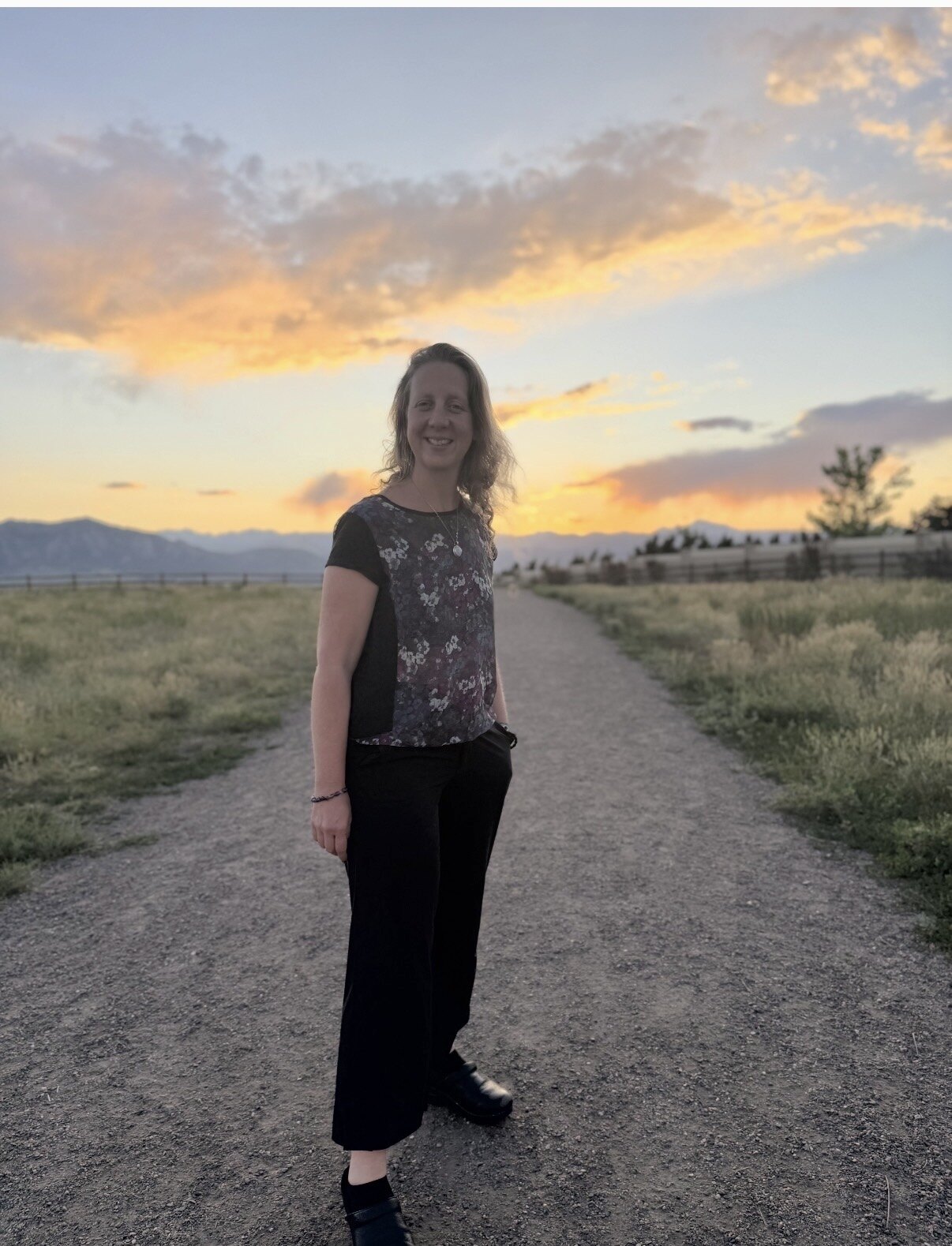 Ashley Millikin standing on a mountain path at sunset